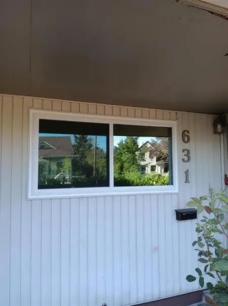 Installer at the door of a cream house with new windows above
