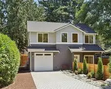 Front elevation of a modern gray two-story house with new windows above the garage
