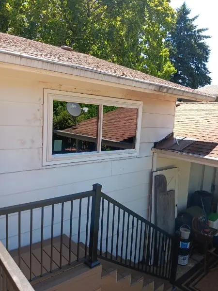Slider window on a white ranch seen from a stair landing